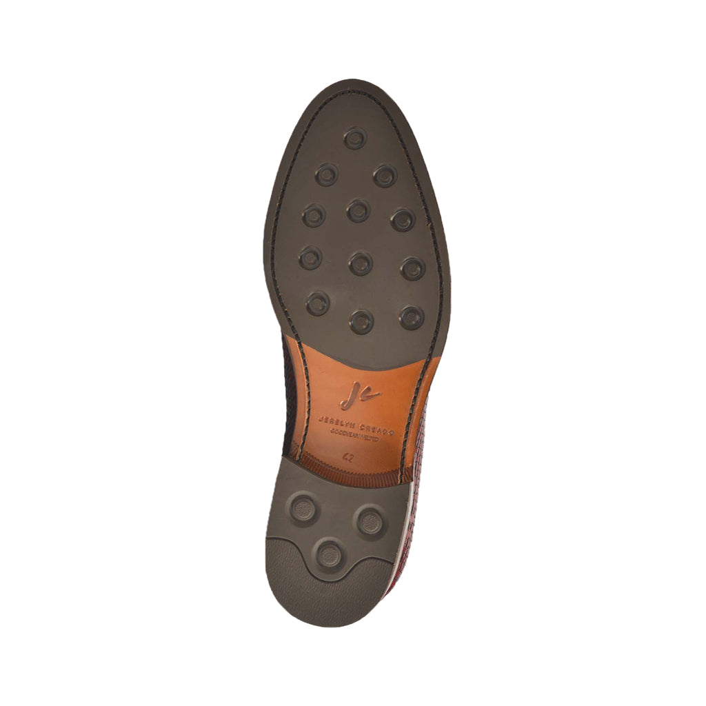 Bottom view of a brown leather dress shoe with a durable rubber sole and grip pattern