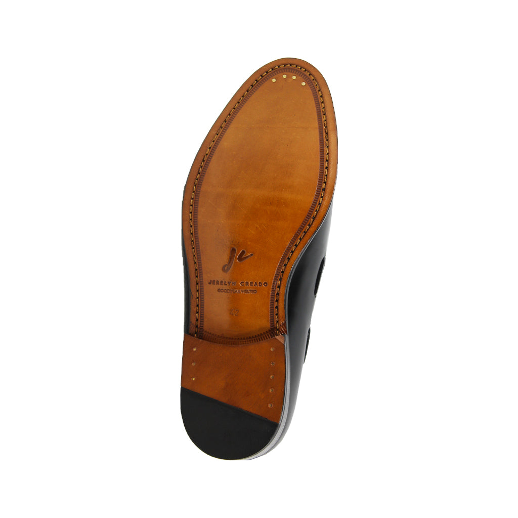 Men's leather dress shoe sole showing brand logo and stitching details