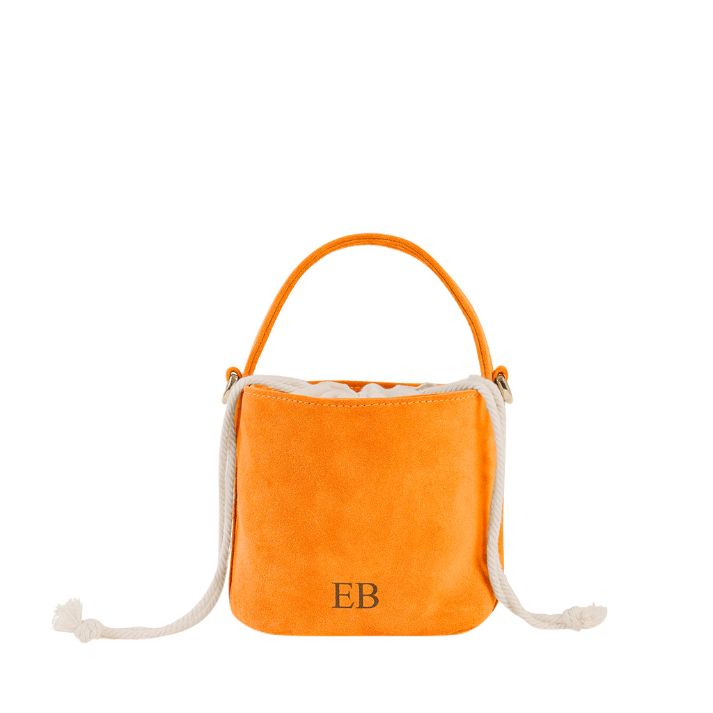 Orange suede bucket bag with white rope handles and the initials EB on the front