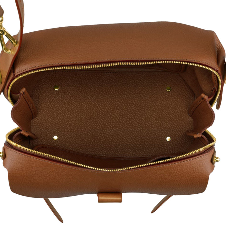 Top view of an open brown leather handbag with gold zippers and an empty interior