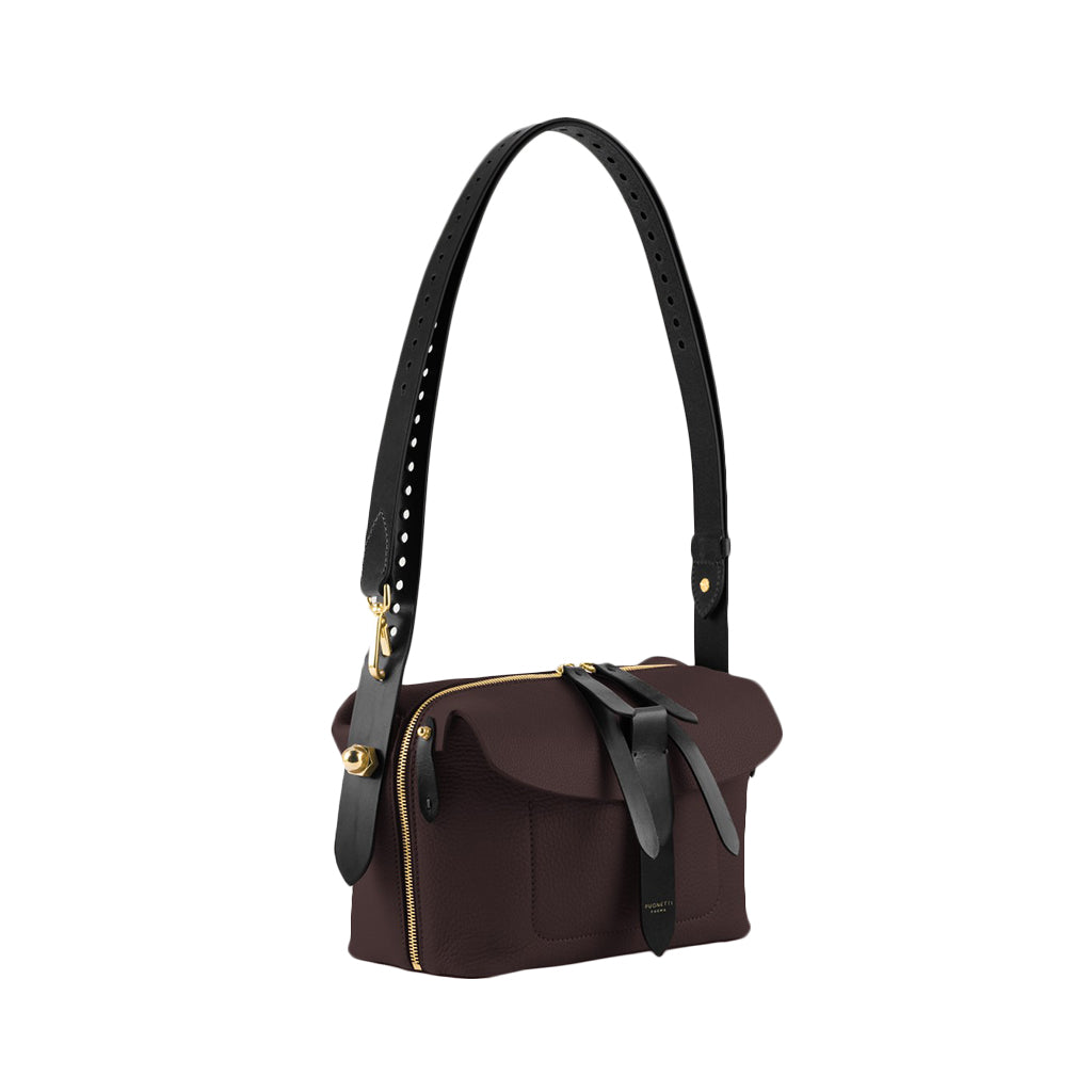 Elegant brown leather handbag with black adjustable strap and gold accents