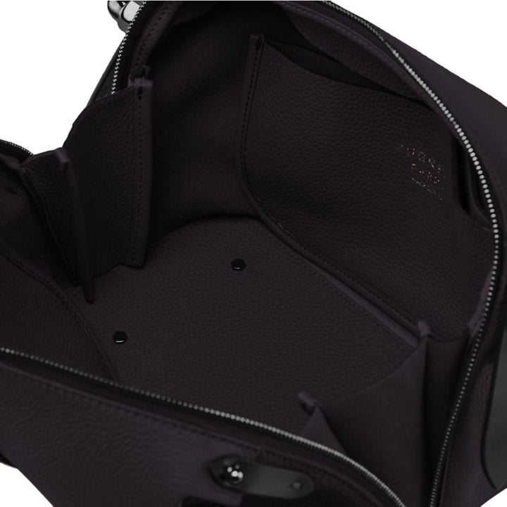 Interior view of a black leather handbag with multiple compartments and zippered top