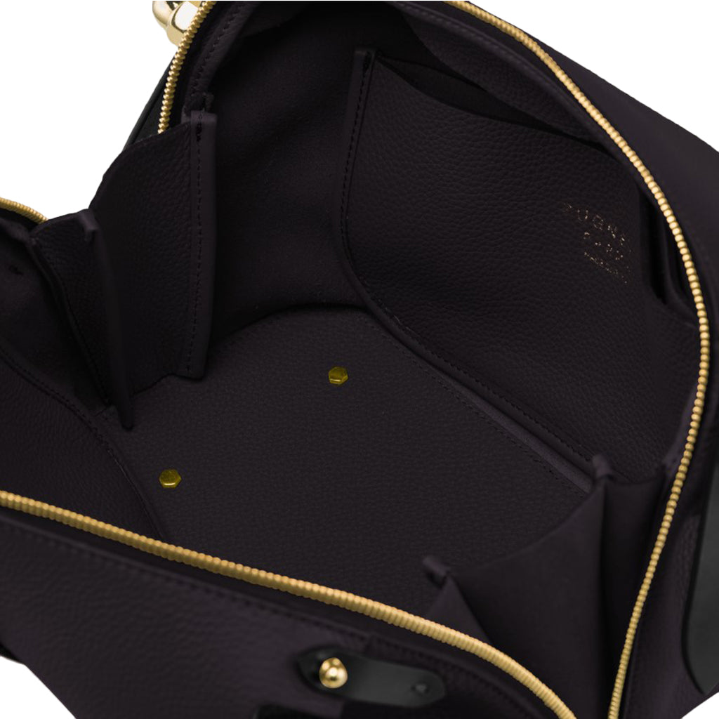 Interior view of an open black leather handbag with gold zippers showcasing internal pockets and compartments