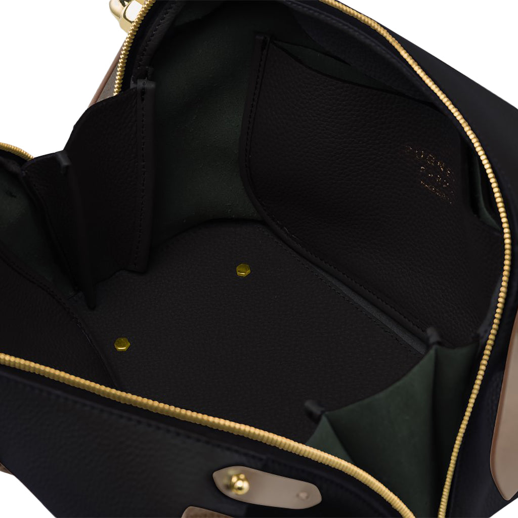 Interior view of an open black leather handbag with pockets and gold hardware