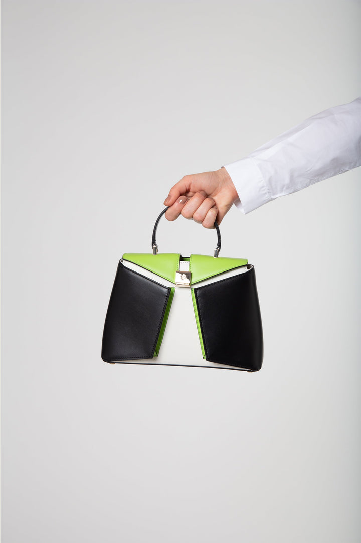 Person holding fashionable black, white, and green handbag