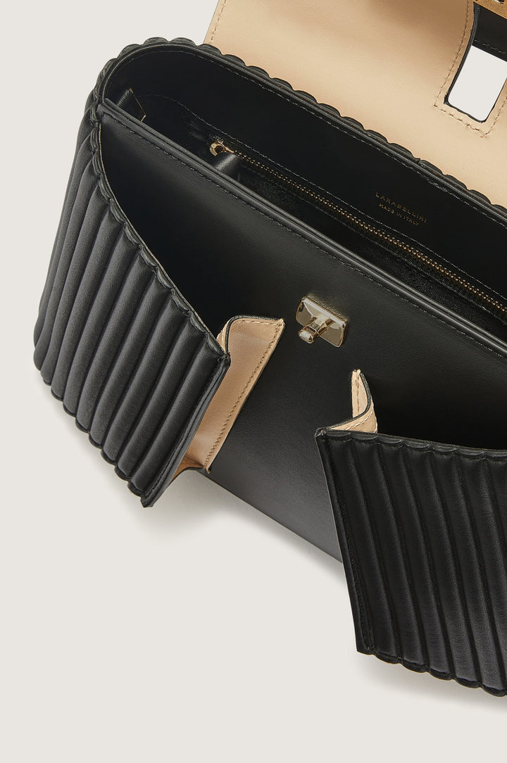 Black leather handbag with gold clasp and beige interior, featuring a ridged design on the sides