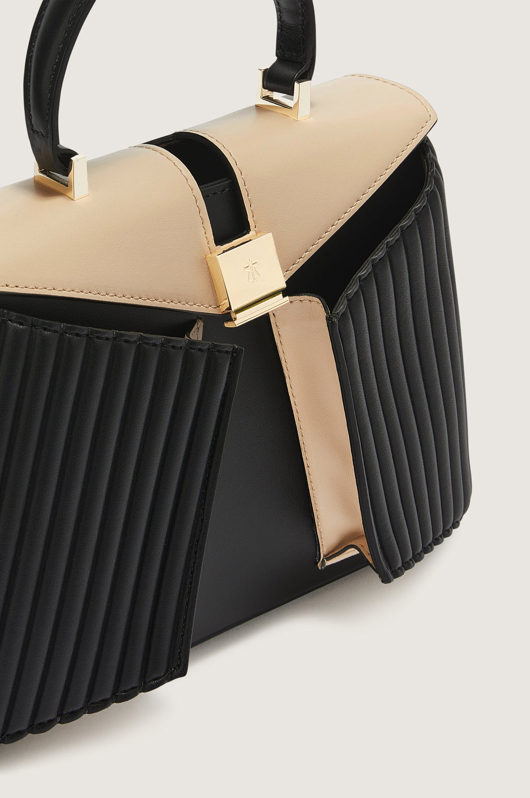 Elegant black and beige handbag with pleated design and gold hardware