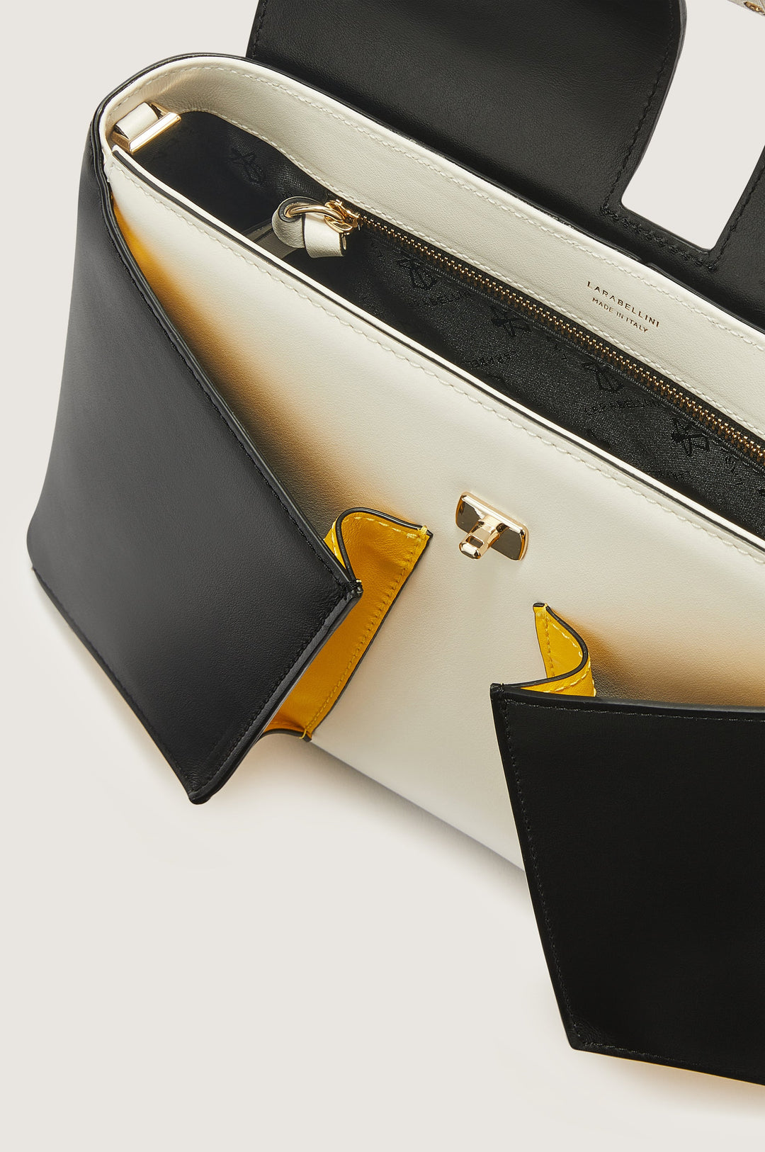 Top view of an open black and white luxury purse with gold accents