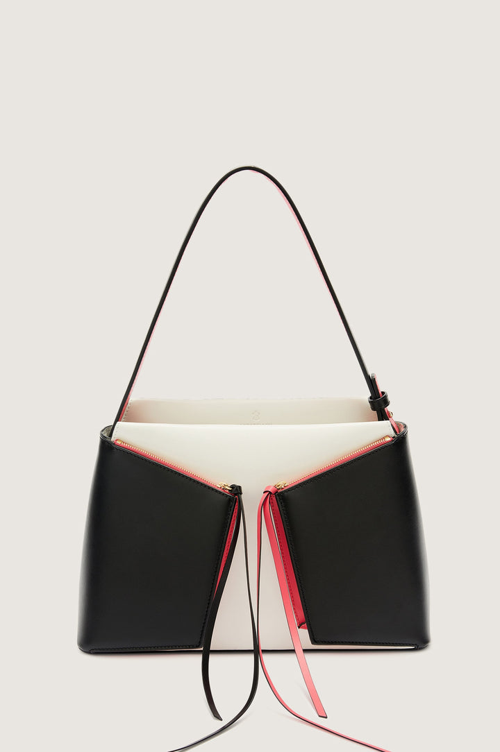 Elegant black and white designer handbag with red accents and shoulder strap