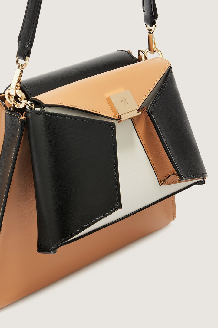 Elegant black, tan, and white leather handbag with a geometric design and gold hardware