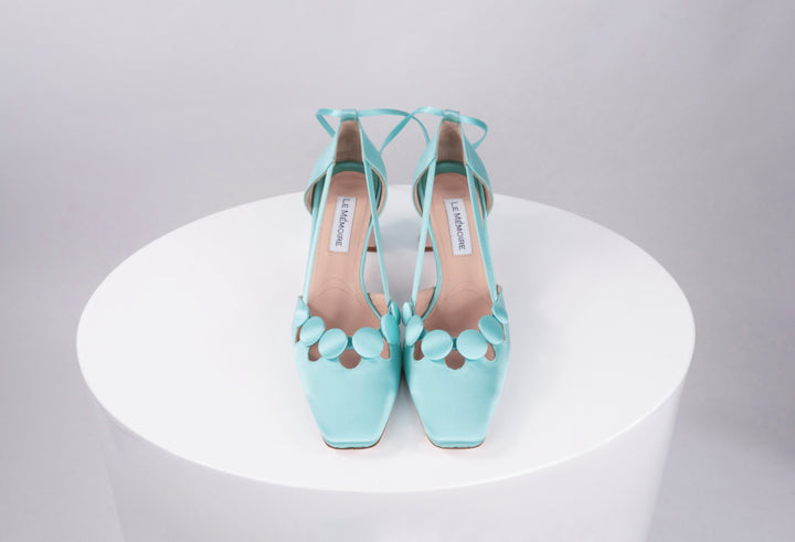 A pair of light blue high-heeled sandals on a white surface
