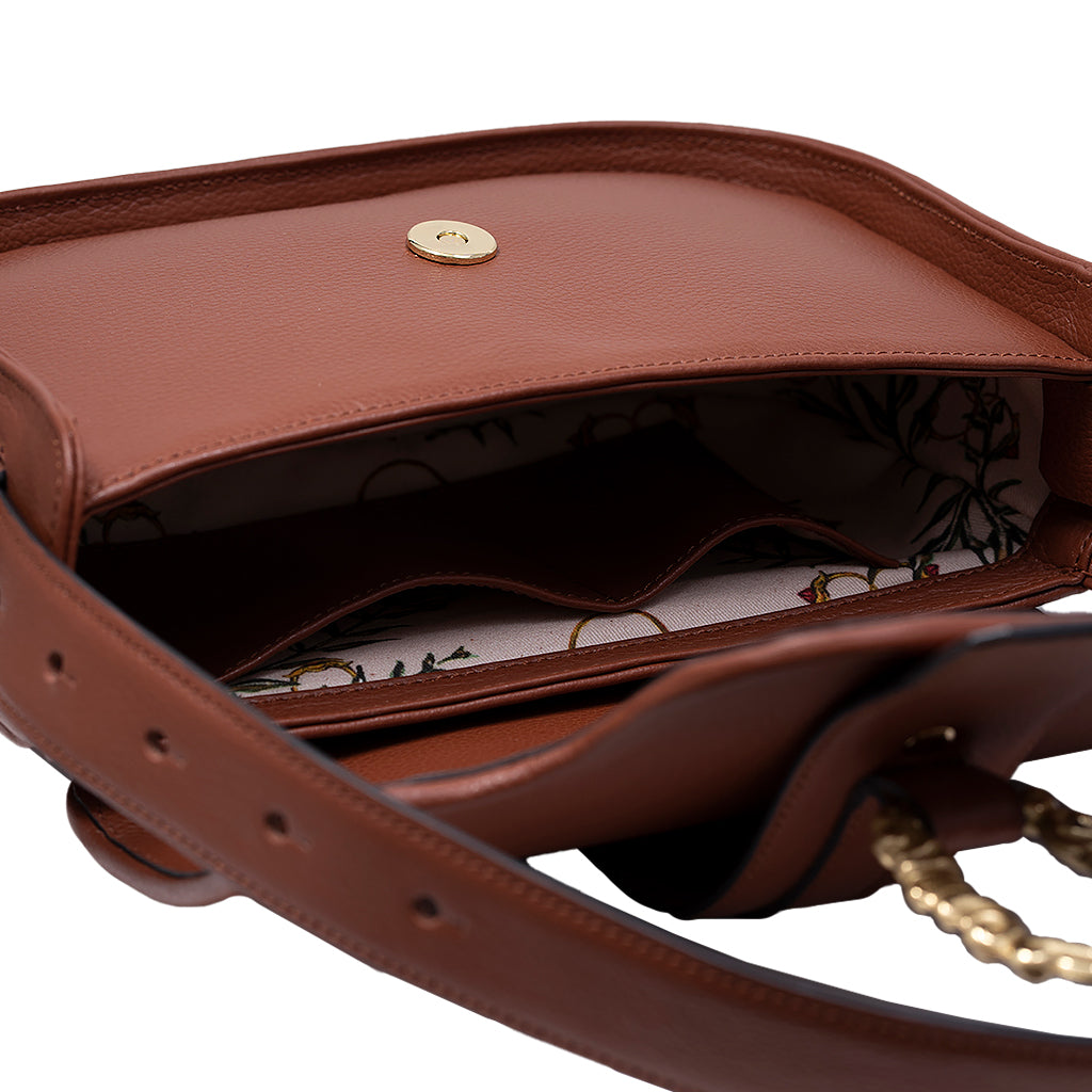 Open brown leather handbag with floral interior pattern and gold button closure