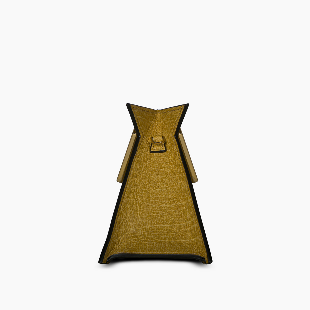 Side view of a yellow textured leather handbag with a triangular shape and handle