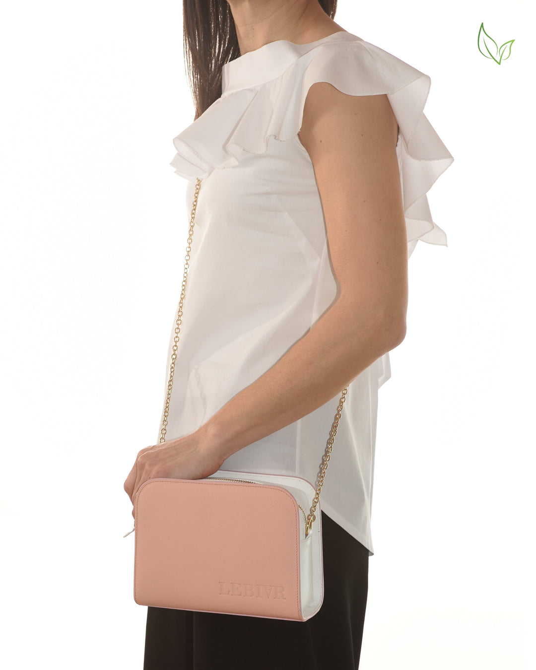 Woman holding a stylish pink and white shoulder bag with gold chain