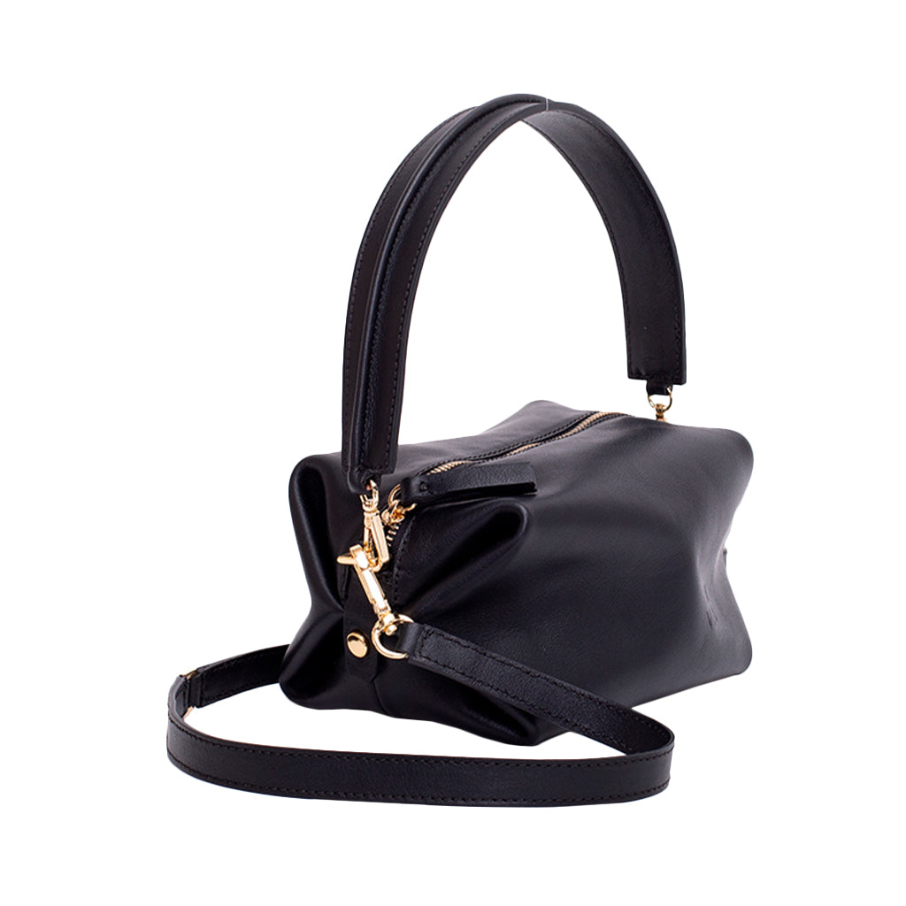 Black leather handbag with gold zipper and accents, featuring a structured handle and adjustable strap
