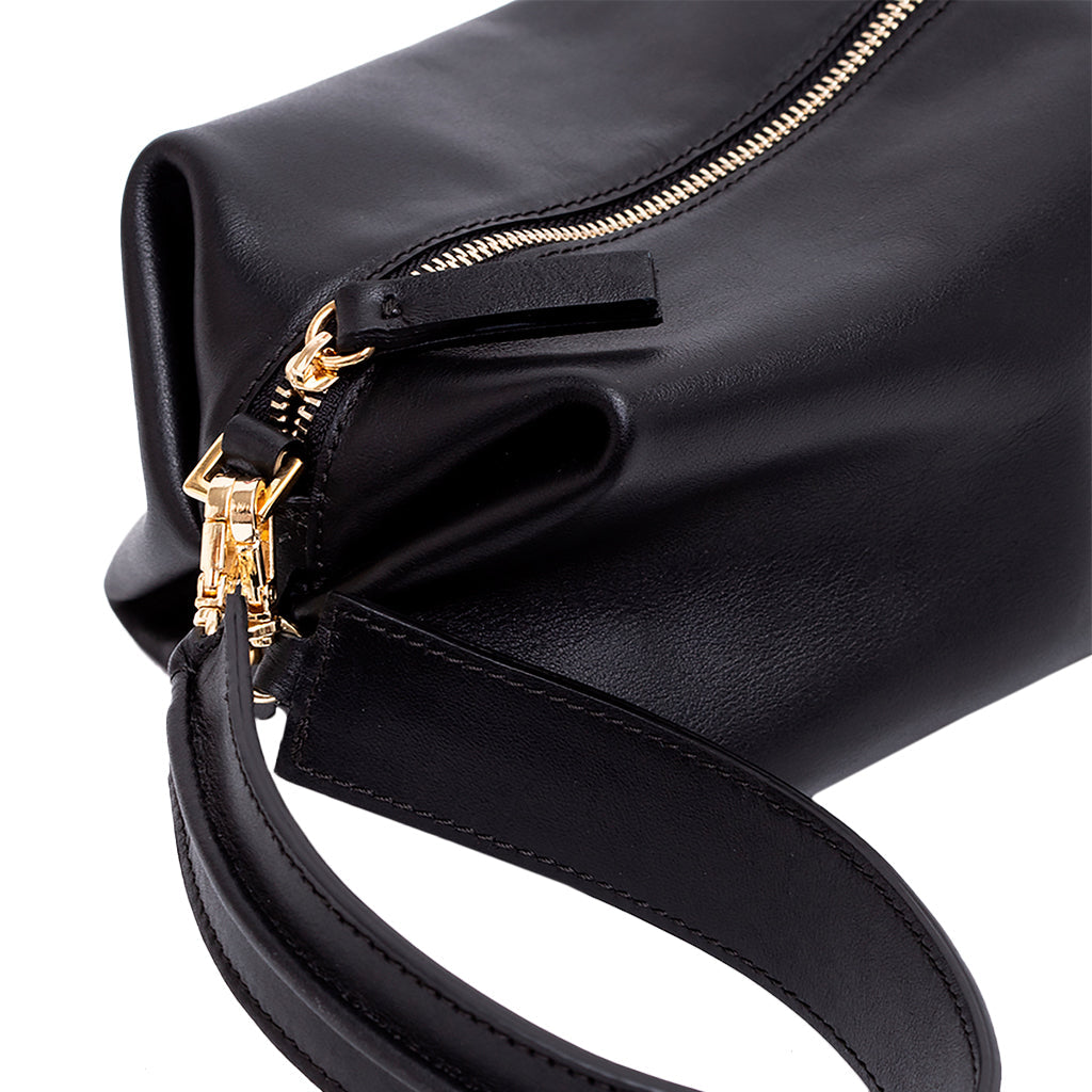 Black leather handbag with gold zipper and strap detail