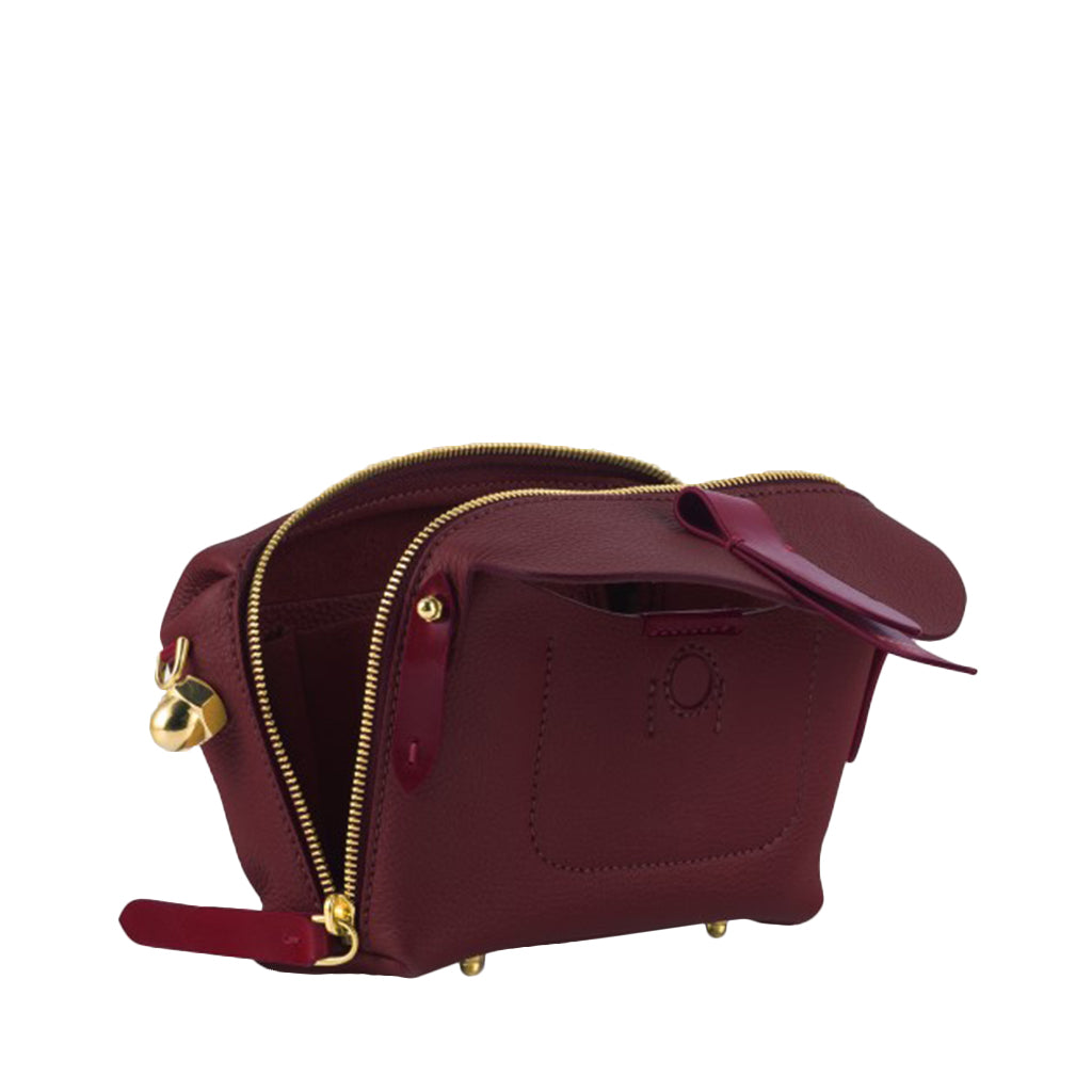 Maroon leather handbag with gold zipper and small bell accessory