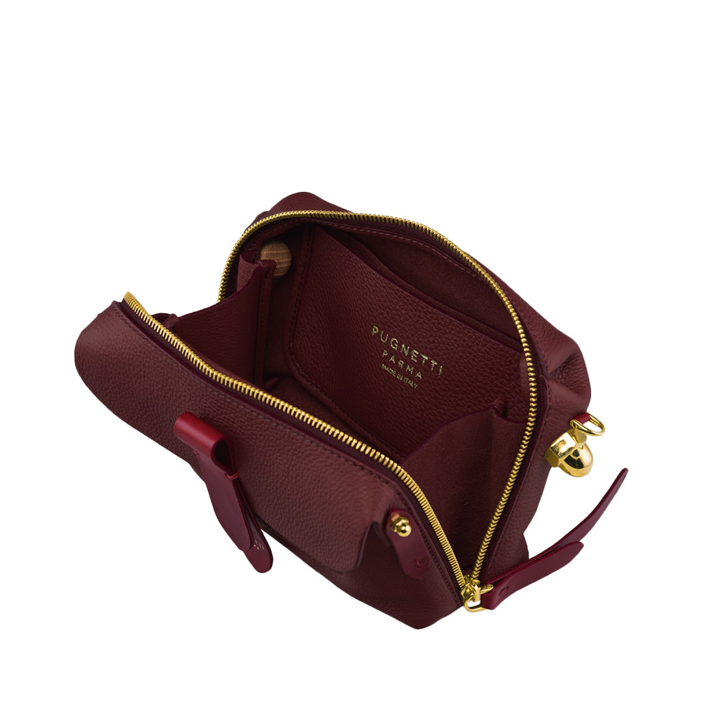 Open maroon leather handbag with gold zipper and interior compartments