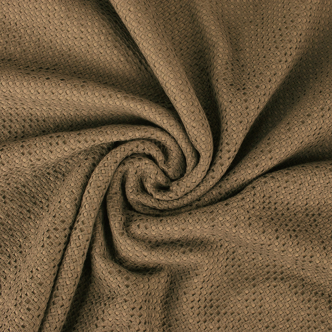 Close-up of textured brown waffle-weave fabric swirled in a circular pattern