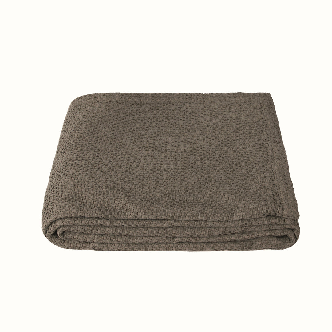 Folded brown textured blanket on a white background