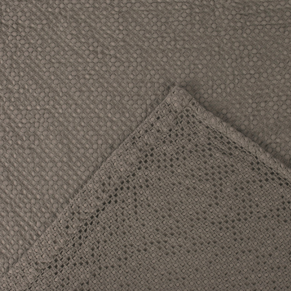 Close-up of textured gray fabric with woven edge