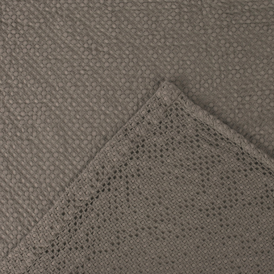 Close-up of textured gray fabric with woven edge