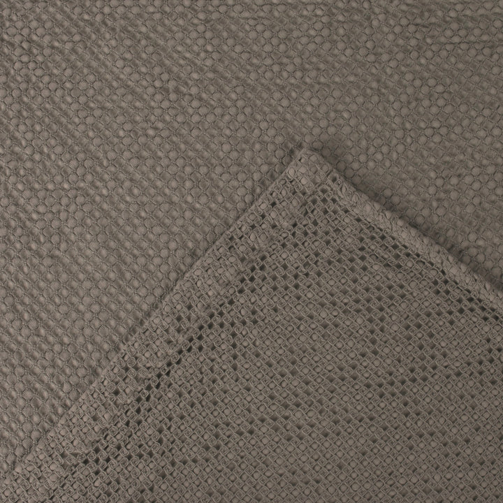 Close-up of textured gray fabric with woven edge