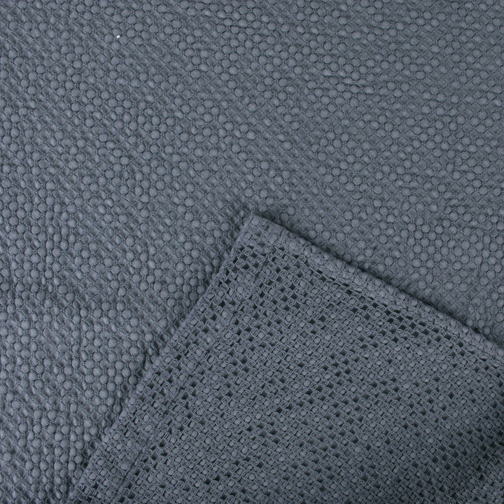 Close-up of a textured dark grey fabric with different woven patterns