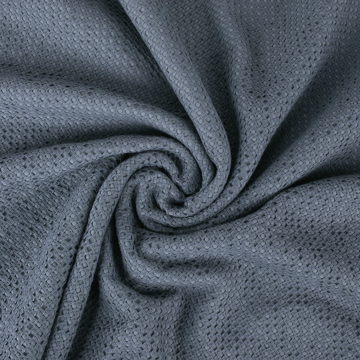 Close-up of a textured gray fabric with a spiral fold pattern