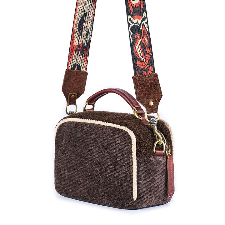 Brown corduroy handbag with decorative strap and leather accents