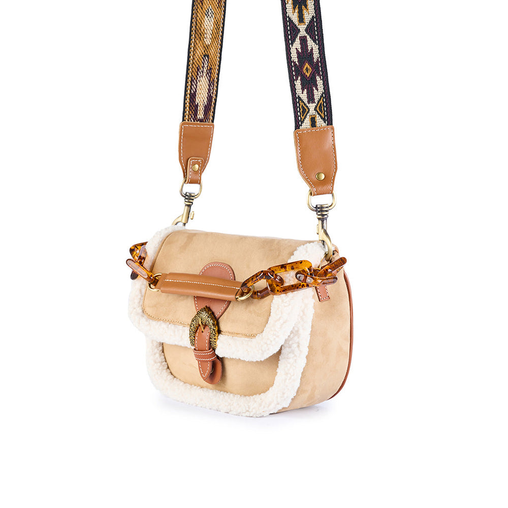 Beige shearling crossbody bag with patterned strap and tortoiseshell chain embellishment