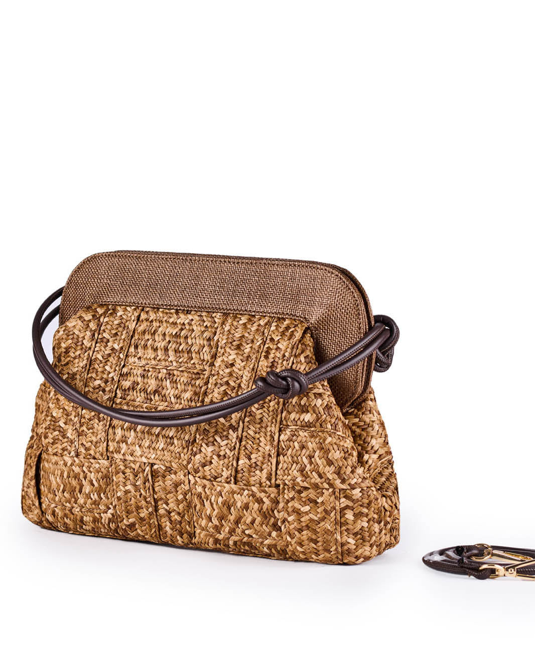Stylish woven straw handbag with brown strap and clasp against white background