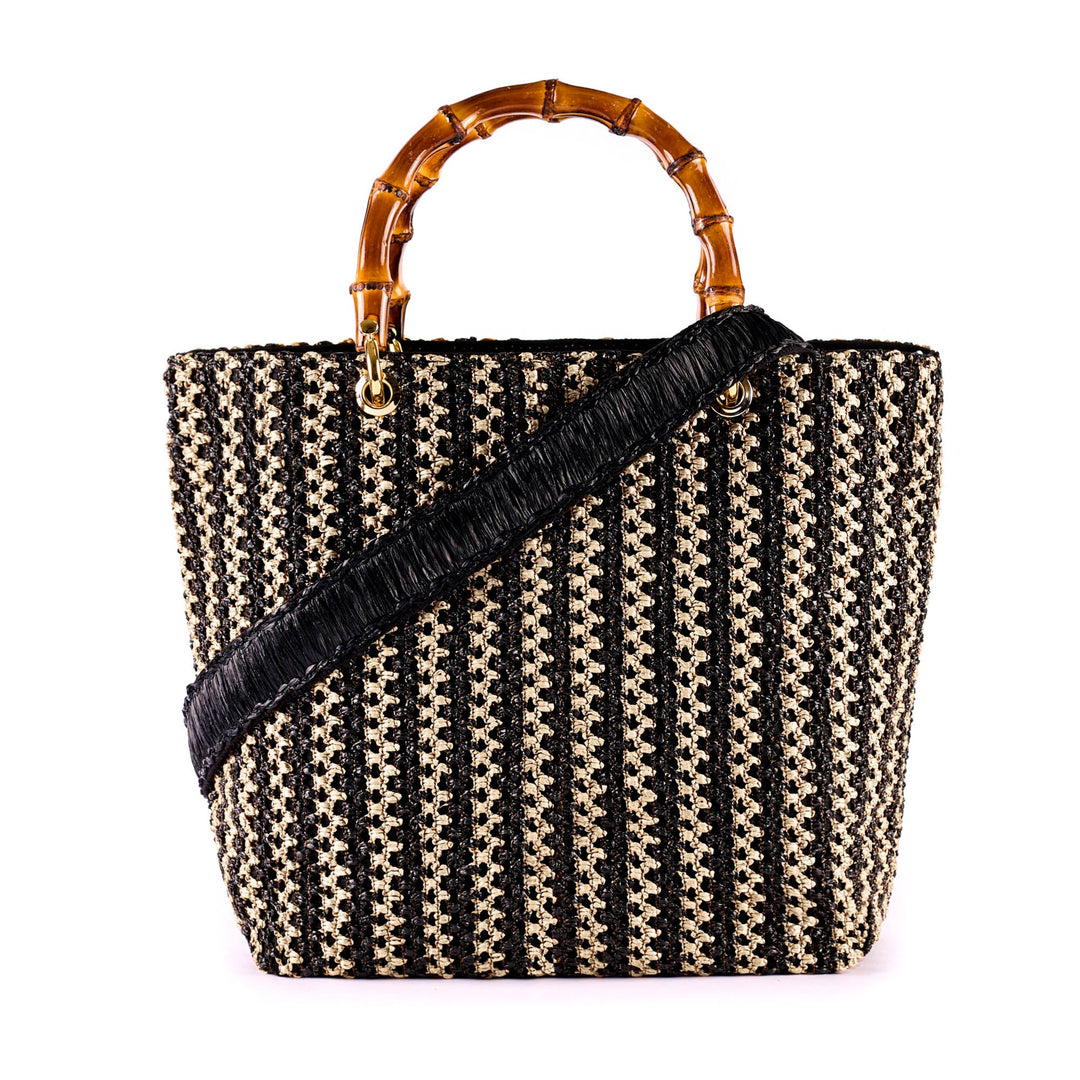 Black and white woven handbag with bamboo handles and black strap