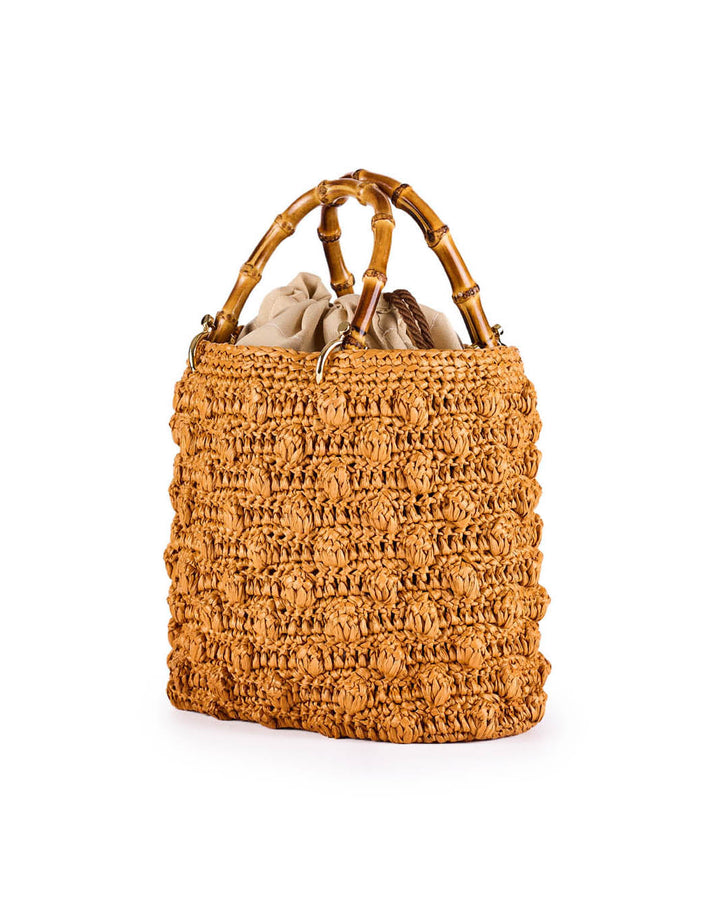 Handmade straw handbag with bamboo handles and beige fabric lining