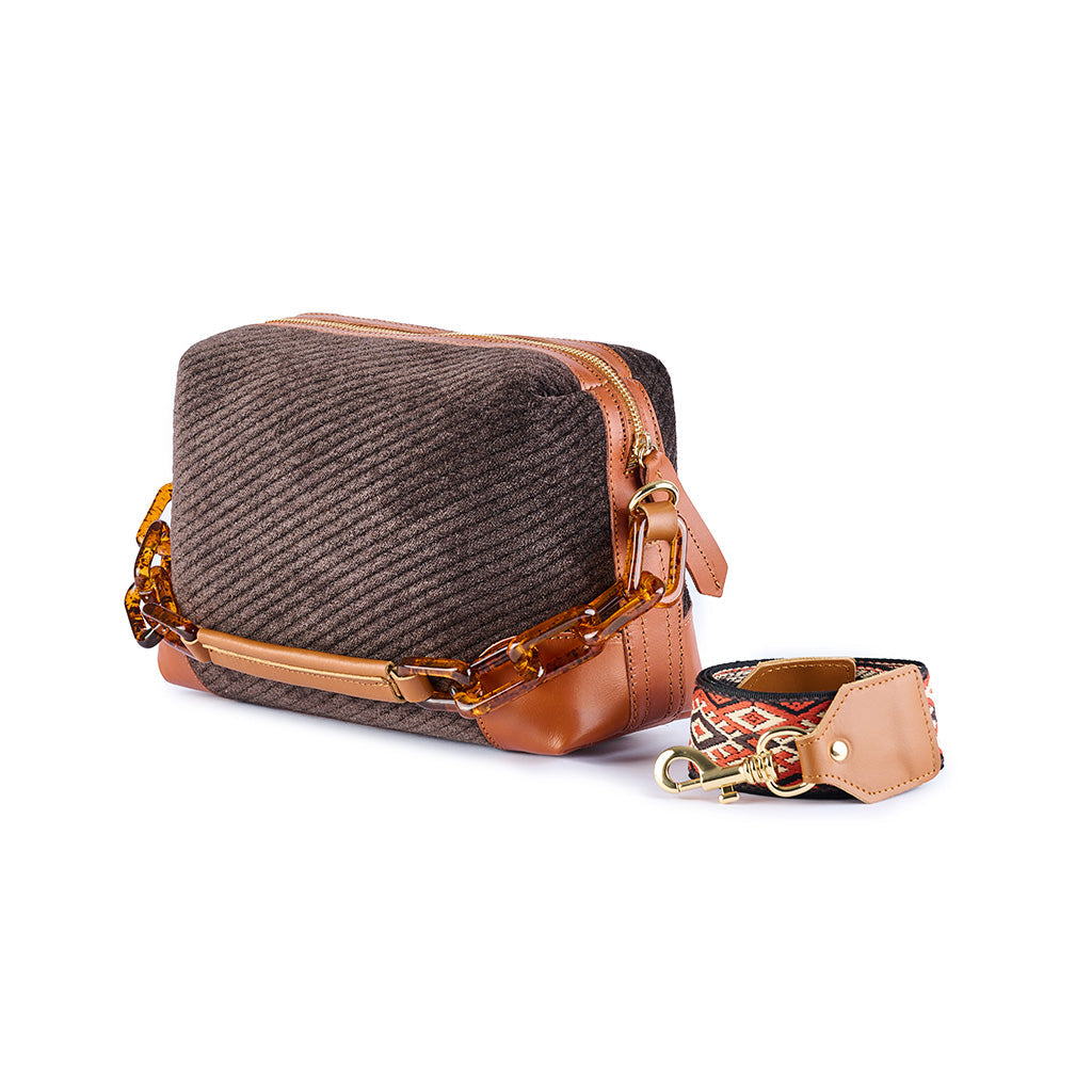Stylish brown textured handbag with leather accents and attachable patterned strap
