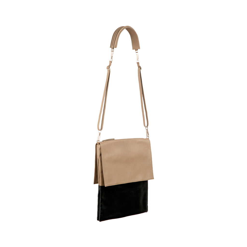 Beige and black leather crossbody bag with adjustable strap against white background