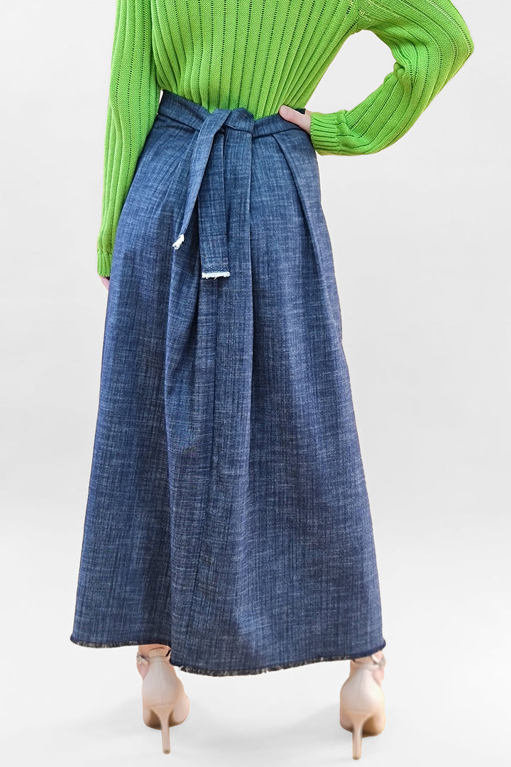 Woman wearing a green sweater and denim midi skirt with a tie waist