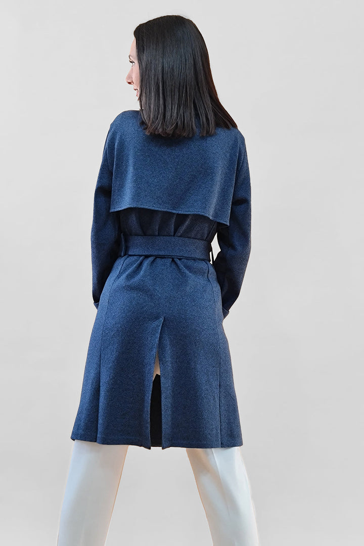 Woman wearing blue coat with belt viewed from the back