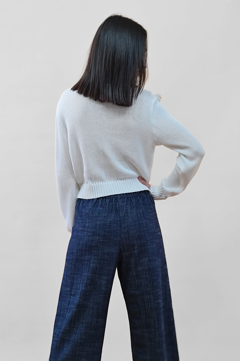 Person modeling casual long-sleeve sweater and wide-leg pants, back view