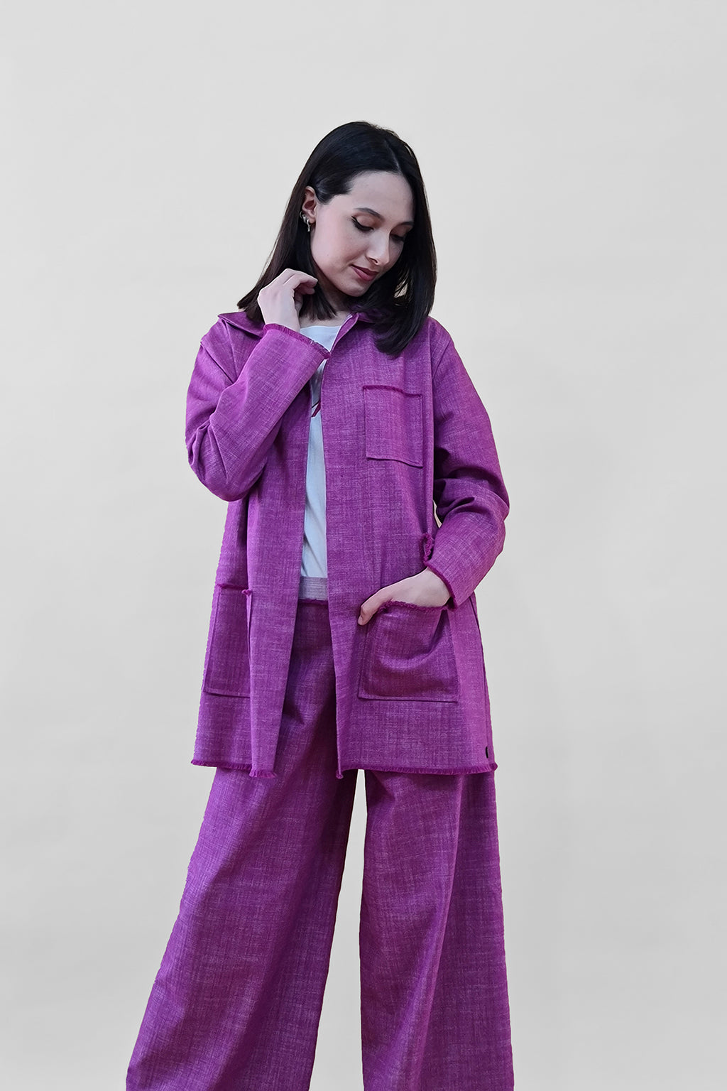 Woman wearing a pink pantsuit with a white background