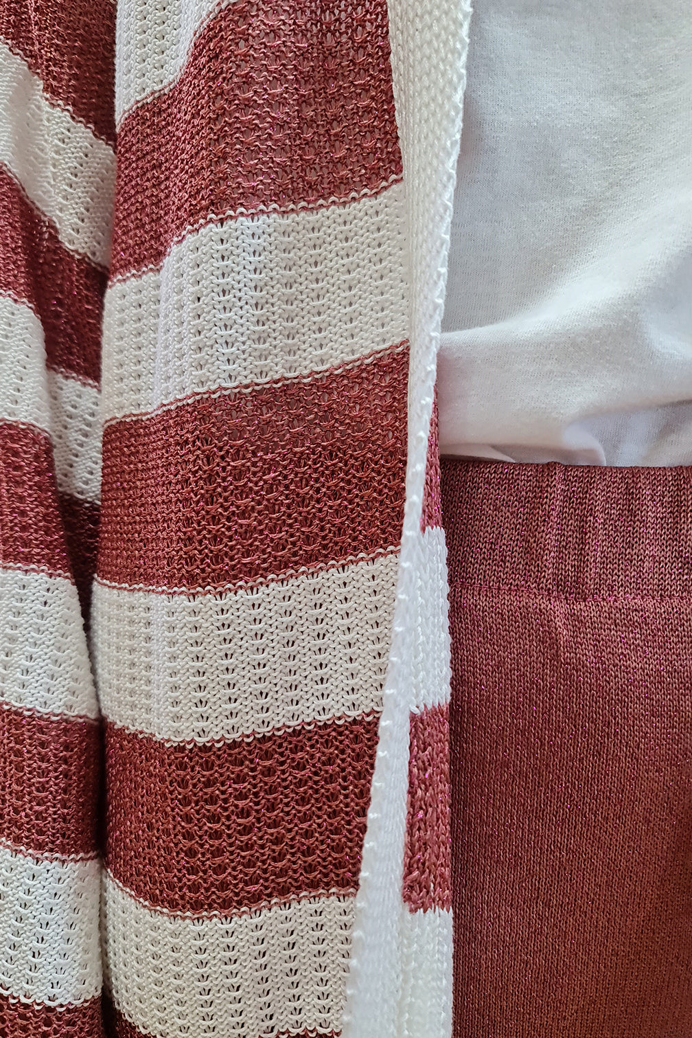 Red and white striped knit fabric with white shirt close-up