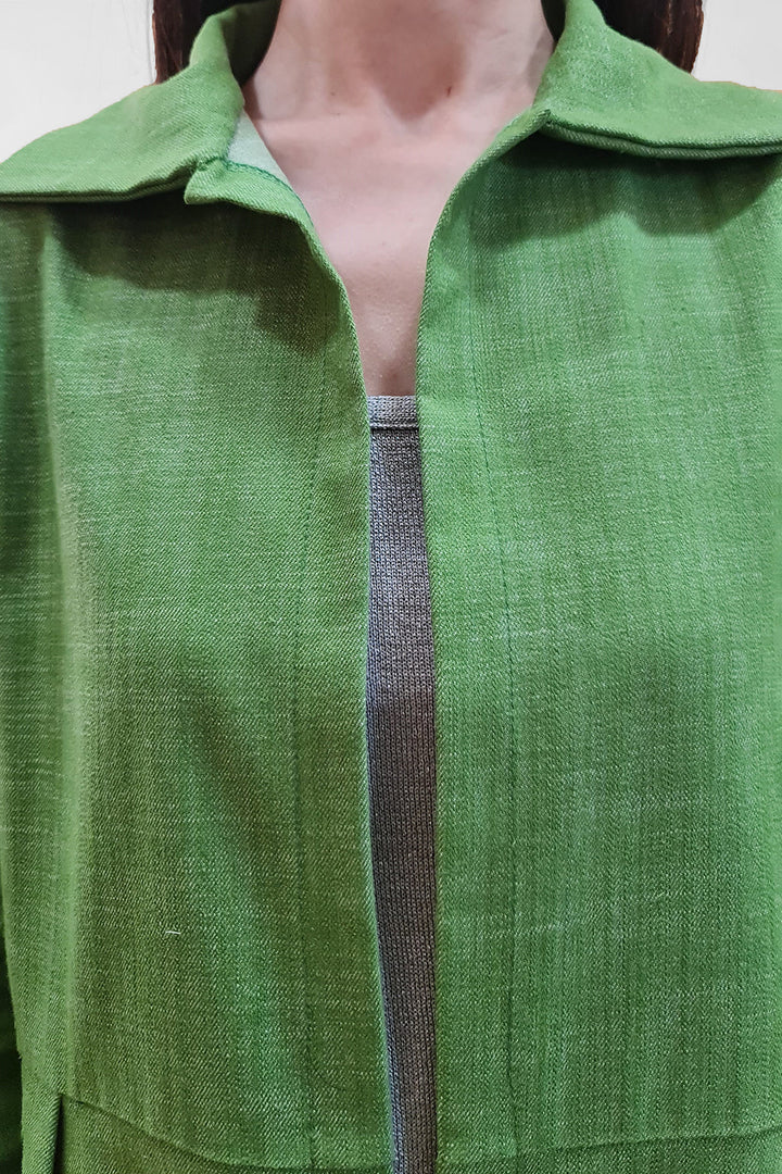 Woman wearing green collared jacket over gray top