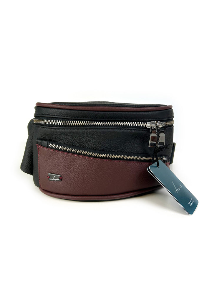 Black and maroon leather fanny pack with double zippers and a tag