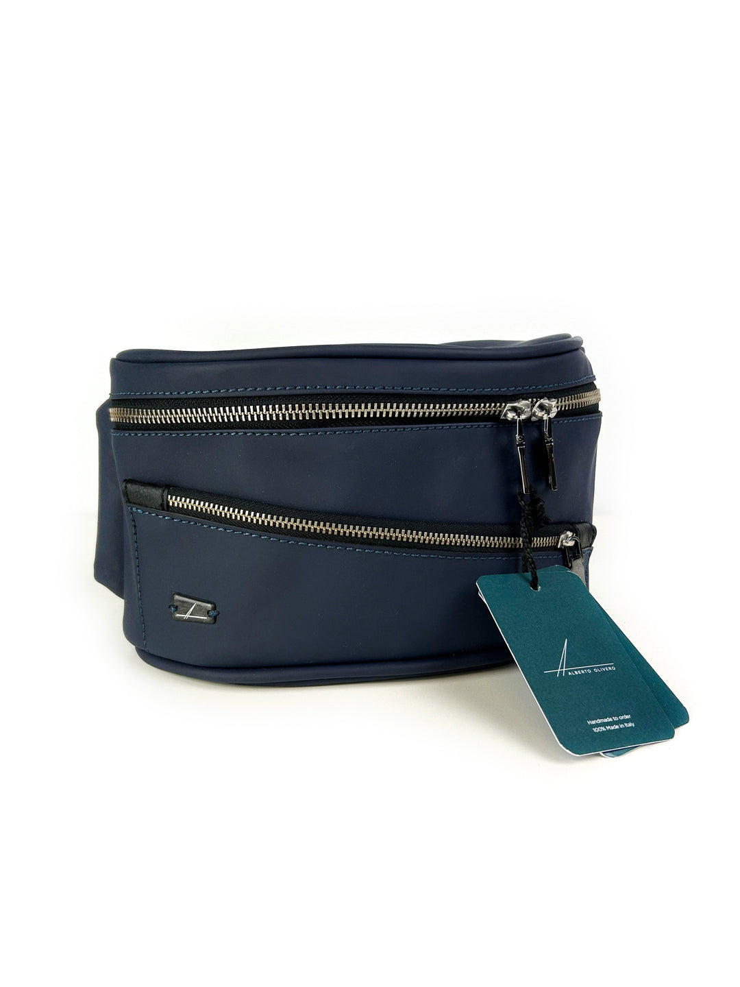 Navy blue fanny pack with multiple zippered compartments and teal tag