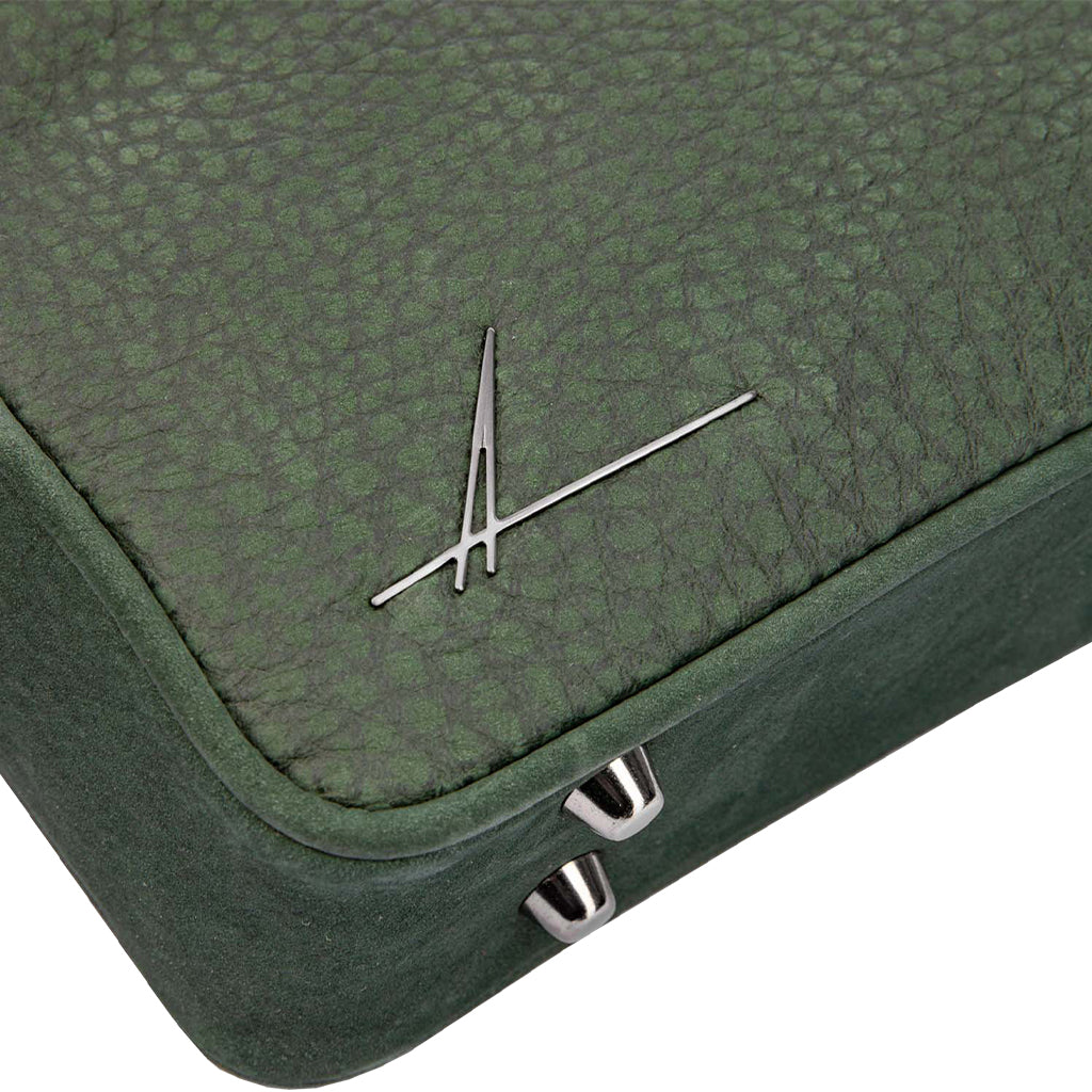 Green textured leather handbag corner with metallic logo and silver hardware