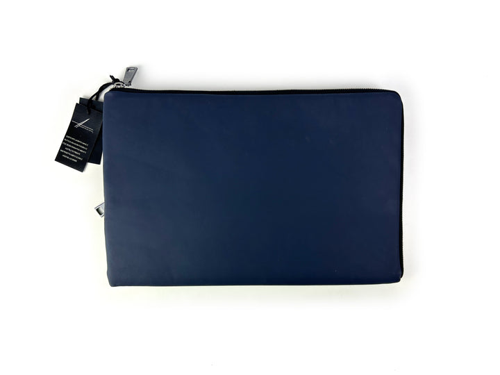 Navy blue laptop sleeve with zipper closure and branded tag