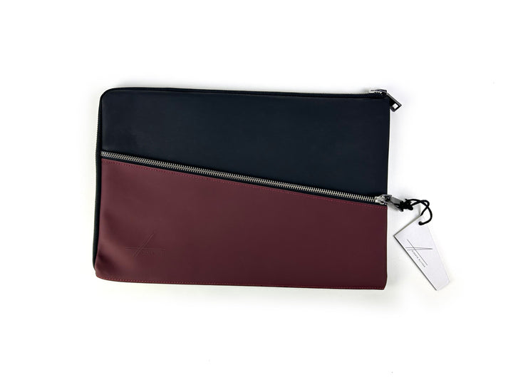 Stylish black and burgundy zippered leather laptop sleeve with tag