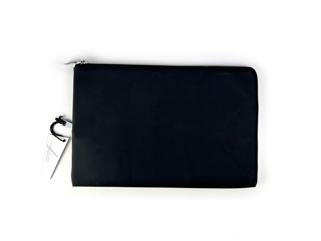 Black leather zipper pouch with a white tag on a white background