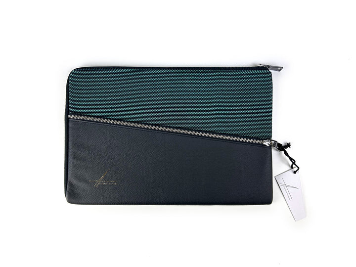 Elegant black and gray zippered laptop sleeve with a textured finish and attached tag