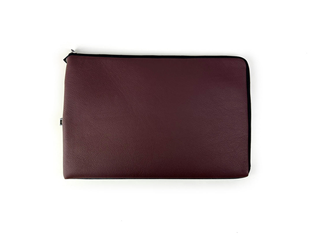 Maroon leather laptop sleeve with black zipper on white background